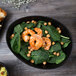 A Libbey Driftstone Onyx porcelain bowl filled with spinach and shrimp.