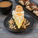 A piece of cake with nuts and caramel on a Libbey Driftstone Onyx satin matte porcelain coupe plate.