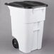 A white Rubbermaid rectangular trash can with black wheels and lid.