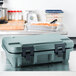 A slate blue plastic Cambro Camcarrier with a lid on a counter.