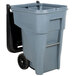 A grey Rubbermaid industrial trash can with black wheels.