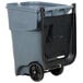 A Rubbermaid grey wheeled rectangular trash can with black wheels and a black lid.