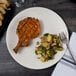 A Libbey Driftwood satin matte porcelain coupe plate with meat and vegetables on a table with a fork.