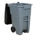 A Rubbermaid grey rectangular trash can with wheels and a black lid.