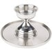 A silver tray with a Cal-Mil stainless steel cake stand on it.