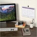 A desk with a computer and an At-A-Glance 2024 wall calendar.