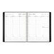 A black At-A-Glance spiral-bound planner with a calendar on it.