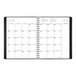 A black At-A-Glance weekly/monthly planner with white pages.