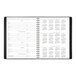 A black spiral bound At-A-Glance planner open to a calendar page with numbers and dates.