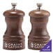 A close-up of a wooden Chef Specialties Capstan salt and pepper mill set.