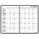 A spiral bound black At-A-Glance monthly planner with white pages and numbers on it.