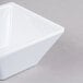 A close up of a white Elite Global Solutions squared melamine bowl.