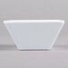 A white square Elite Global Solutions melamine bowl on a gray surface.