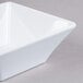 A white square bowl on a gray surface.