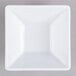 A white square bowl with black edges on a gray surface.