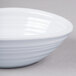 A white Elite Global Solutions swirl melamine bowl on a gray surface.