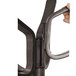 A hand holding an espresso brown wood coat stand with metal hooks.