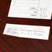 A close-up of a white carbonless Adams Guest Check receipt on a table.