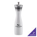 A white and wood pepper mill with a black and silver lid.