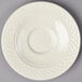 A white Homer Laughlin china saucer with a circular pattern on the edge.