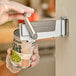 A wall-mounted can opener being used to open a can of green lima beans.
