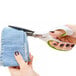 A hand using Westcott CarboTitanium scissors to cut a piece of jeans.