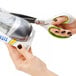 A hand using Westcott CarboTitanium scissors to cut a small card.