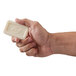 a hand holding a white square object