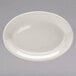 A white Tuxton oval china platter with a wide rim on a gray surface.