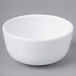 A white Elite Global Solutions Merced melamine bowl on a gray surface.