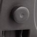 A black plastic knob on the black Alera office chair surface.