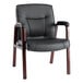A black leather chair with wooden legs.