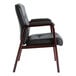 An Alera black leather arm chair with wooden legs in a lounge area.
