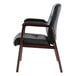 A black leather Alera Madaris arm chair with wooden legs.