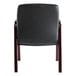 The back of a black leather Alera Madaris arm chair with wooden legs.