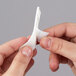 A person's hands using a white 3M Command Picture Hanging Strip to hang a piece of paper.