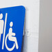 A white sign on a blue wall using 3M Command White Medium Picture Hanging Strips.