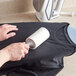 a person using a lint roller to remove clothes