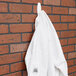 A white jacket hanging on a 3M Command White Large Wire Hook on a white wall.