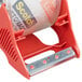 A red 3M tape dispenser with a clear plastic roll inside.