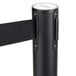 A black Aarco crowd control stanchion with dual black retractable belts.