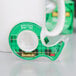A green 3M Scotch tape dispenser with black and white text on a white table.