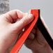 A person holding a roll of 3M Scotch black mounting tape.