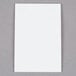 A white rectangle of 3M Scotch clear mounting strips on a gray surface.