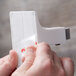 A person using a 3M clear mounting strip.