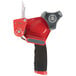 A red and grey 3M Scotch heavy-duty tape dispenser gun.