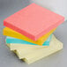 A stack of 3M Post-It notes in assorted colors on a counter.