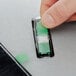 a finger holding a green and white strip