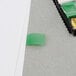 A green 3M Post-It page flag on a white piece of paper.
