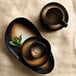 A black and brown tiger organic porcelain tray with a cup and saucer on a table.